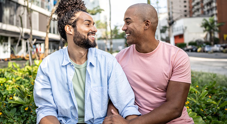 same-sex couple smiling and looking at one another